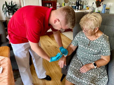 Ein Pfleger gibt einer Patientin eine Spritze